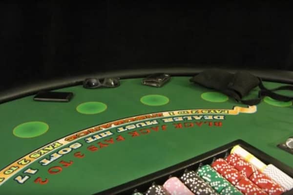 The blackjack table has sunglasses, a purse, a wallet and a phone on it The blackjack table has sunglasses, a purse, a wallet and a phone on it