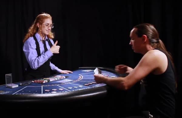 The player is holding their cards over the table The player is holding their cards over the table