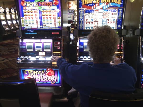 An older woman playing the slots An older woman playing the slots