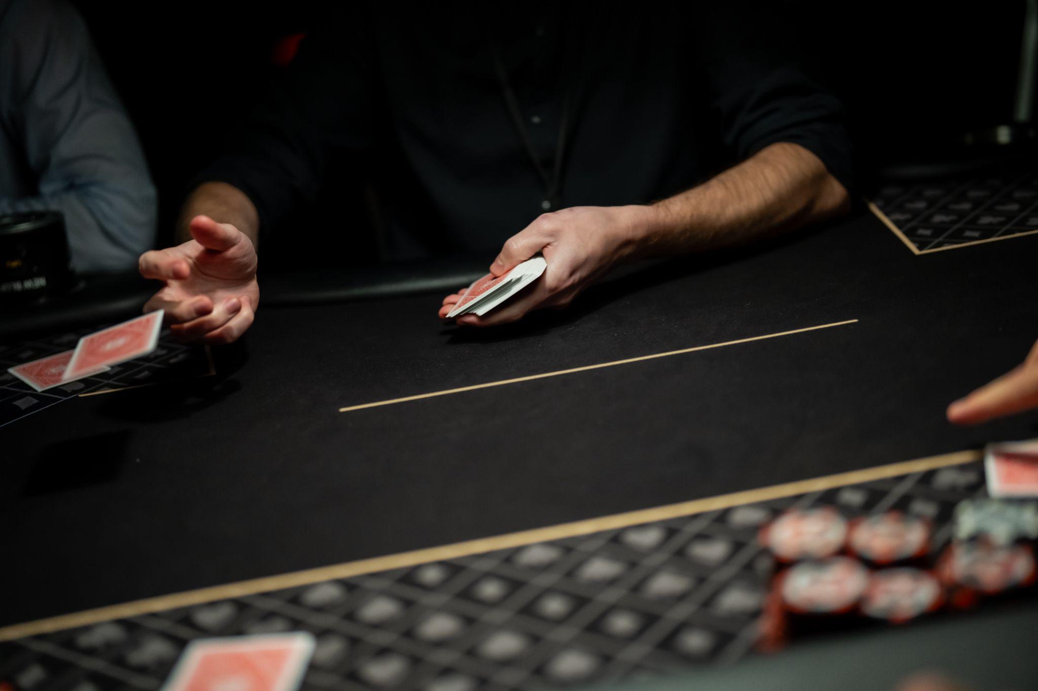 the dealer is pitching cards on a poker table